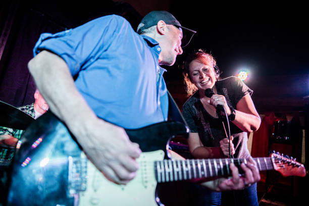 istock Rock band singing and playing guitar during performance at nightclub 2159708428