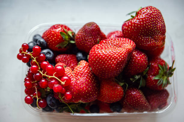 Delicious strawberries and other berries i in a bowl on a white background. High quality photo