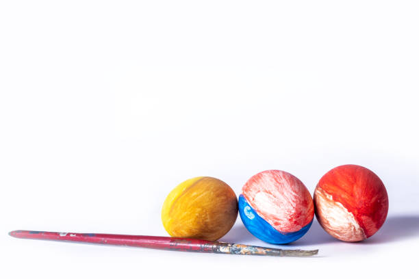 Colorful painted Easter eggs and paint brush on white background