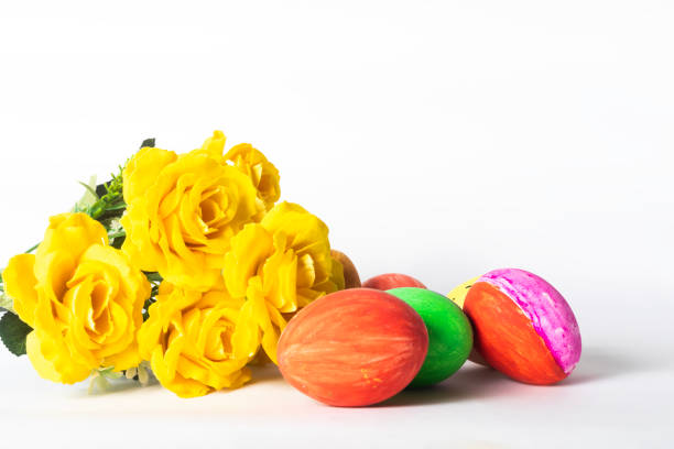 Easter eggs and yellow roses isolated on white background with copy space. Happy Easter