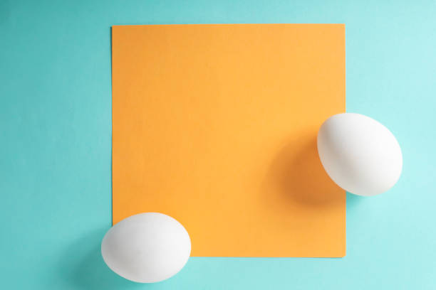 istock Two white eggs with yellow card on a blue background. Top view, flat lay, Minimal easter concept 2159713338