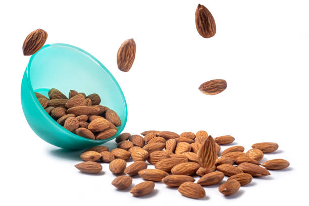 istock Almonds falling from a blue bowl isolated on white background. clipping path included. 2159713754