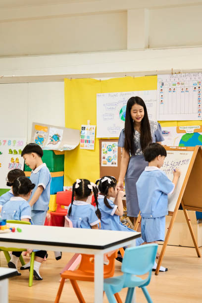 istock Students writing on whiteboard in kindergarten class with teacher 2159715002