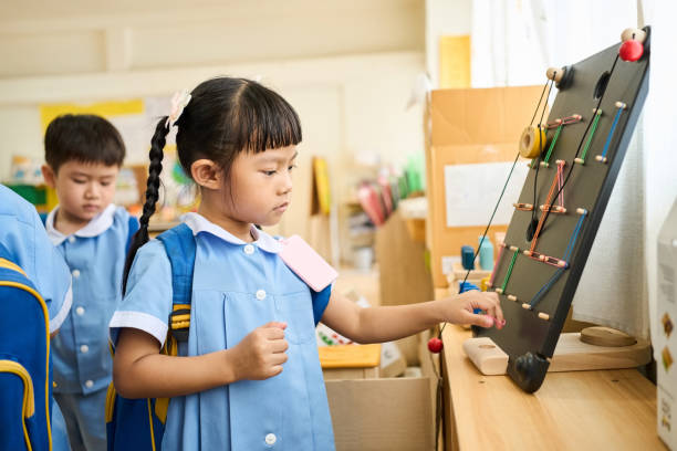 Cute girl student playing with a toy while leaving the classroom in kindergarten school
