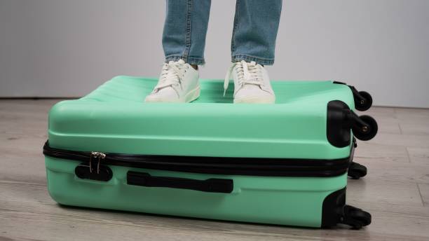 istock Woman standing with her feet on a suitcase. 2159715696