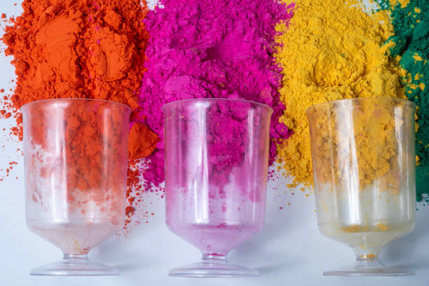 Colorful holi powder with empty glass vase on white background. Top view