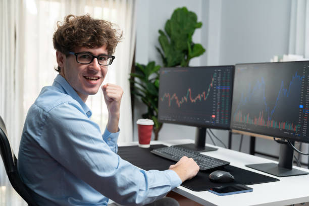 istock Profile of smiling stock trader sitting against on dynamic graph screen. Gusher. 2159716636