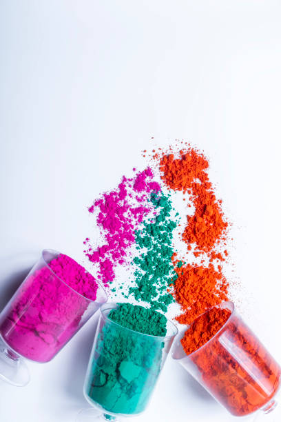 istock Colorful holi powder in a plastic containers on white background. 2159716644