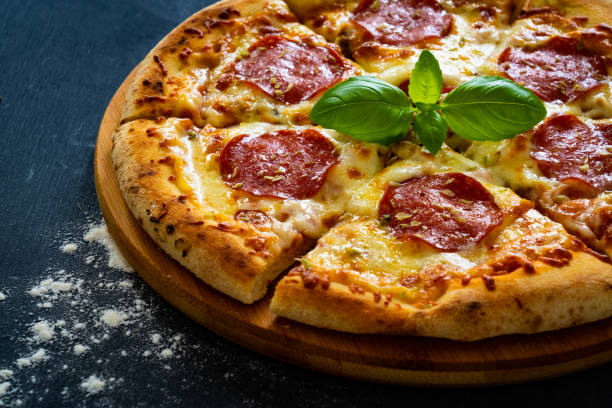 istock Circle pepperoni pizza with mozzarella cheese on black wooden table 2159717836