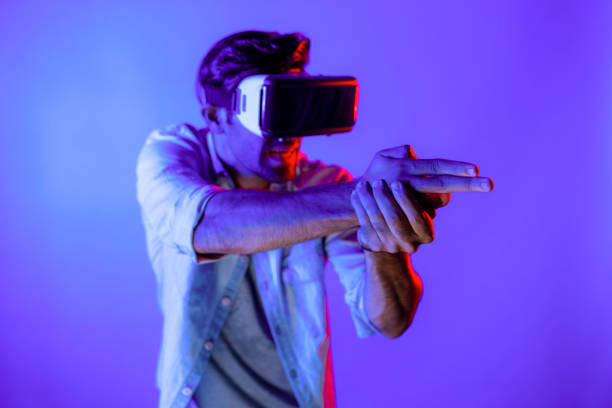 Caucasian smart man wearing VR glass and moving gesture holding gun. Gamer using future digital virtual reality headset or futuristic innovation to enter meta world or playing action game. Deviation.