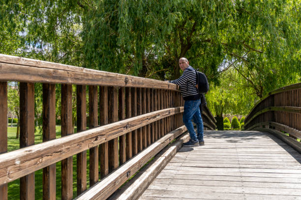 istock Man contemplates the rural environment from a wooden peunte de madera 2159720936