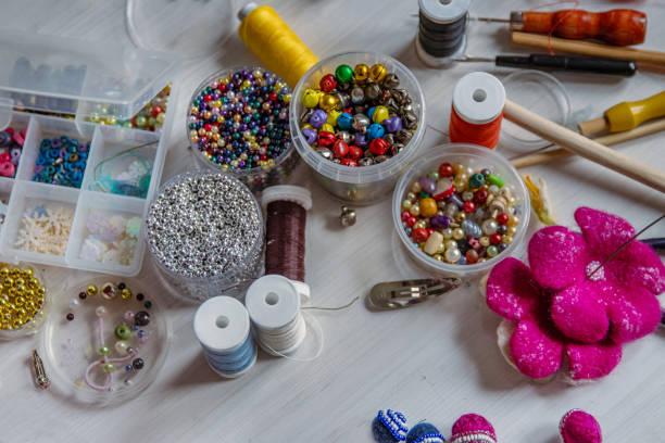 istock Creating Christmas ornaments. Handcraft artist workspace. Laptop, colorful beads, felt, tools, scissors, needles, thread spools, glue, containers, pliers, wire. Creative chaos concept. Flat lay. 2159720973