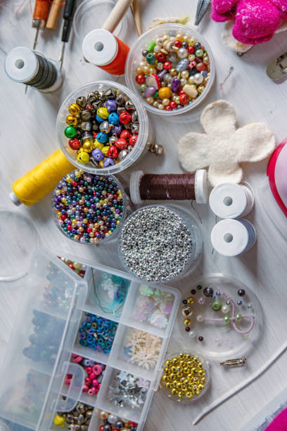 istock Creating Christmas ornaments. Handcraft artist workspace. Laptop, colorful beads, felt, tools, scissors, needles, thread spools, glue, containers, pliers, wire. Creative chaos concept. Flat lay. 2159721213
