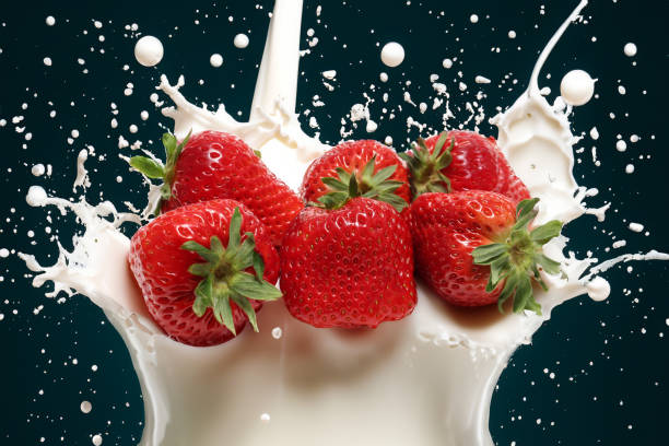 istock Strawberries and milk splash on a black background. 2159721317