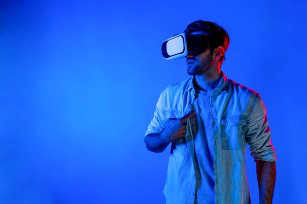 istock Man with casual cloths wearing VR goggles and pointing at himself. Deviation. 2159724210
