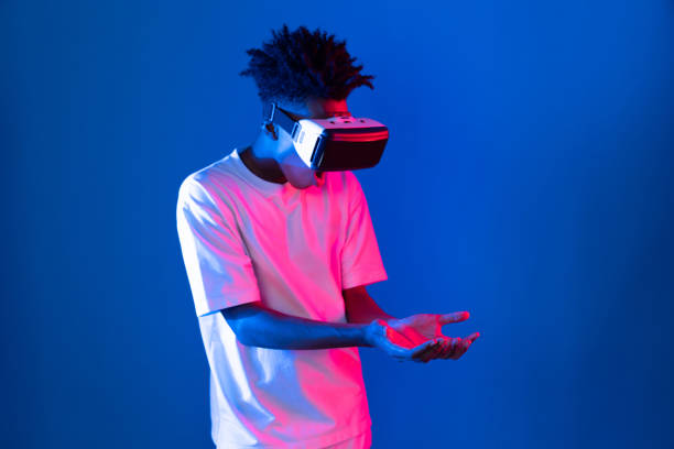 istock Surprised African looking VR holding object hologram neon wall. Contrivance. 2159725495