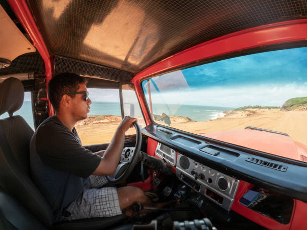 istock Man driving car on the beach 2159728502
