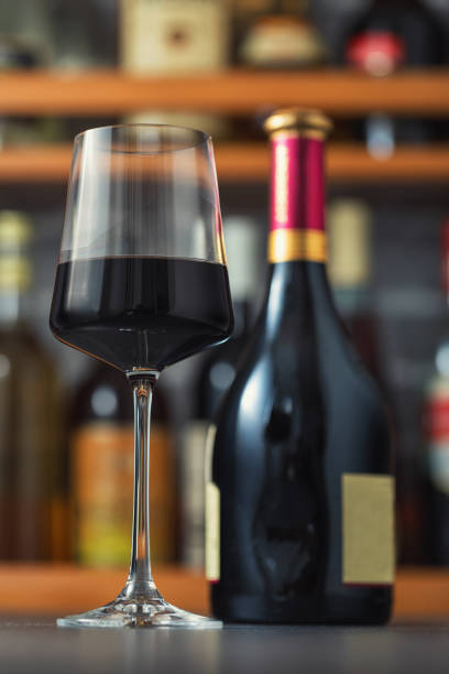 istock Red wine bottle and red wine glass on a wooden table 2159731032