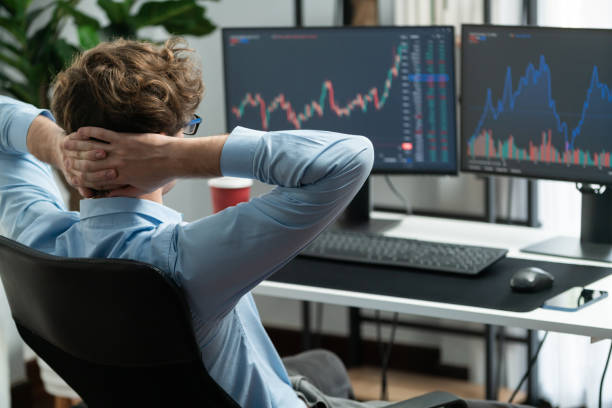istock Trader leaning body back looking on dynamic screen at modern office. Gusher. 2159736591