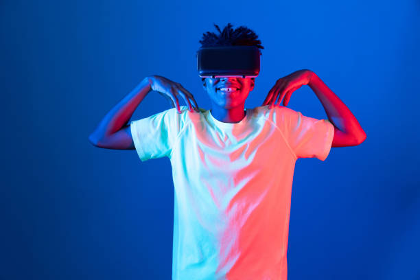 istock African sport player wearing VR stretching arm neon light wall. Contrivance. 2159744131