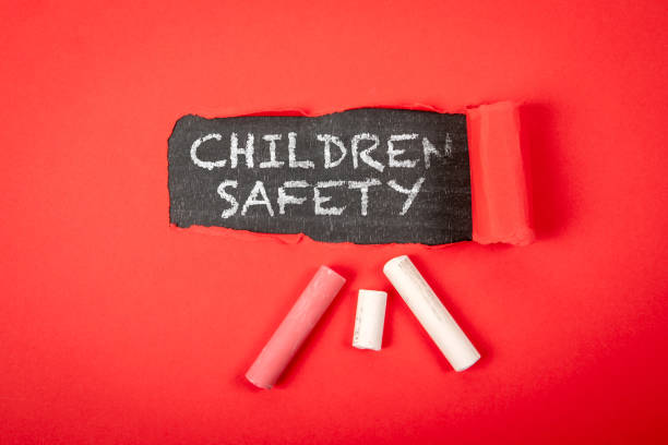 istock Children Safety. Text under torn red paper on a blackboard 2159744733