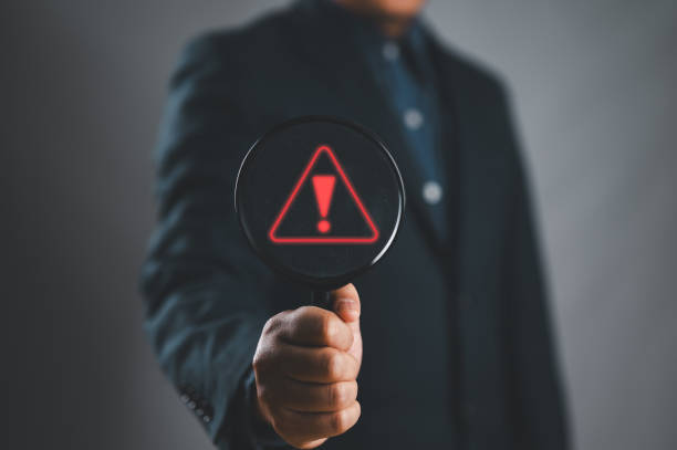 istock Businessman using laptop showing warning triangle and exclamation sign icon Warning of dangerous problems server error 2159744806