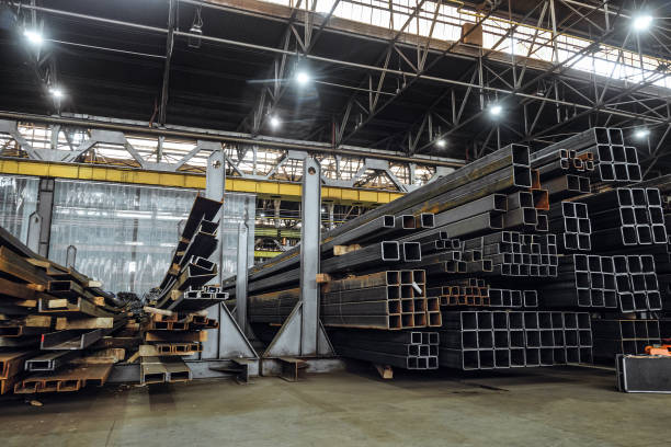 istock Warehousing workshop of rolled metal constructions in industrial metalwork production hall. Steel closed profiles metal structures in stack. 2159745178