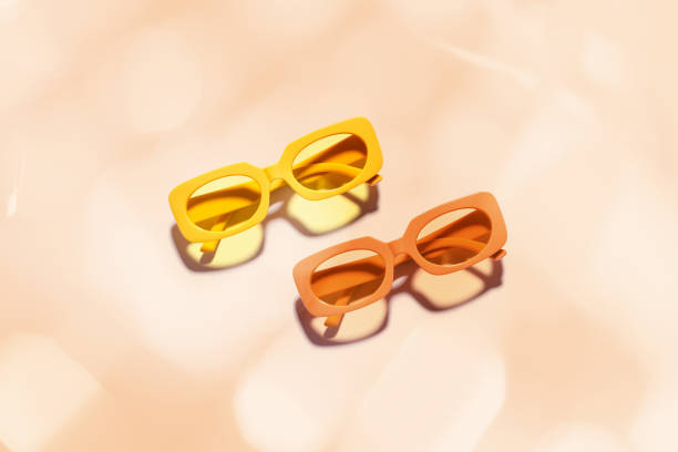 istock Trendy sunglasses with Yellow and orange Frame on peach background, copyspace, beach vibes, summertime mood, sunlight shadow and glare, summer fashion glasses. Minimal top view of eyeglasses 2159747294