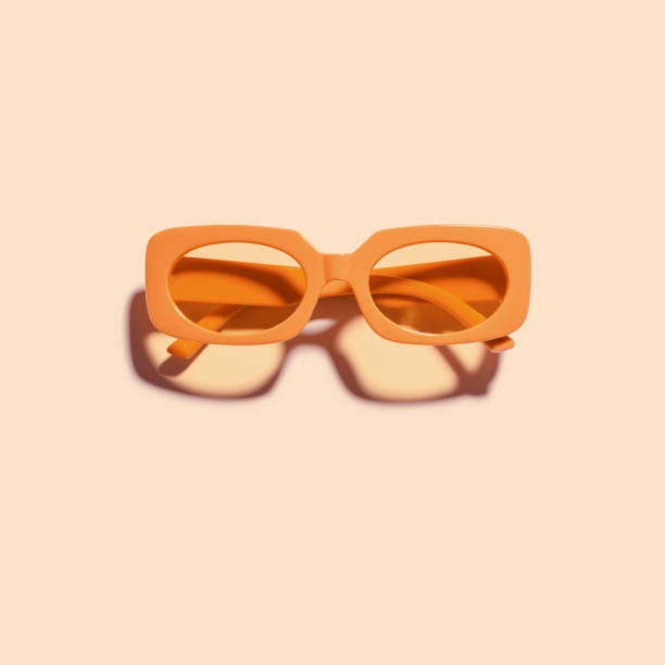 istock Trendy sunglasses with orange Frame on peach color background, copy space, beach vibes, summertime mood, sunlight shadow and glare, summer fashion vivid glasses. Minimal top view of eyeglasses 2159747296