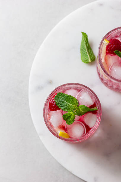 istock Raspberry cocktail with ice in a glass on a light background 2159750224