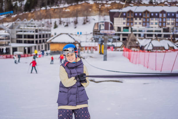 Woman skier climbs a mountain on a ski lift for beginners.