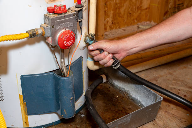 istock Plumber's hand connecting drain hose to water heater 2159757449