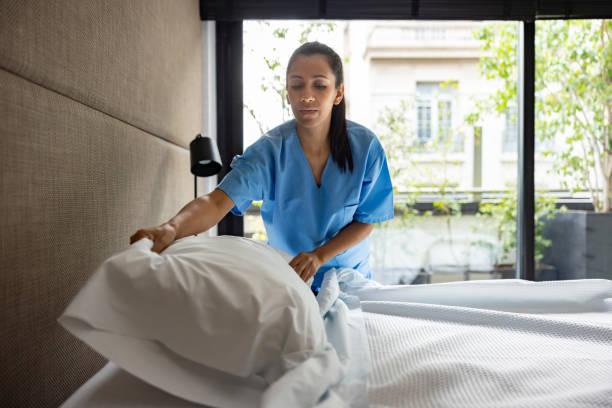 istock Nurse working at a nursing home and making the bed in a bedroom 2159758098
