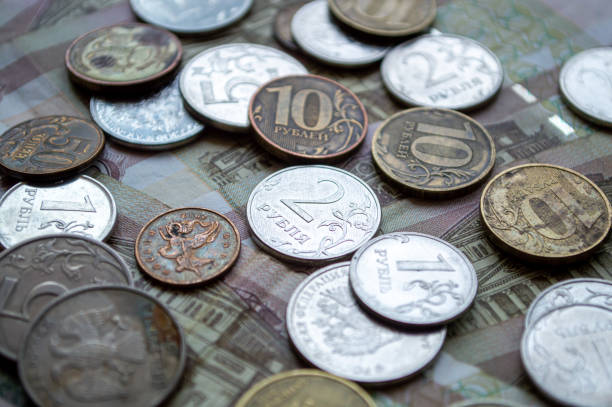 istock Russian currency, coins and banknotes lie on a wooden surface 2159759886
