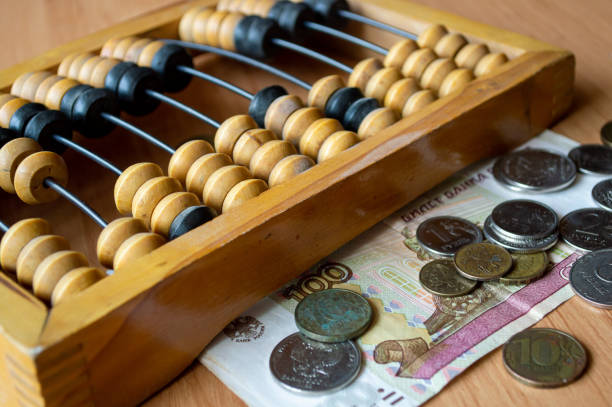 istock Russian currency, coins, banknotes and hand abacus lie on the surface 2159762498