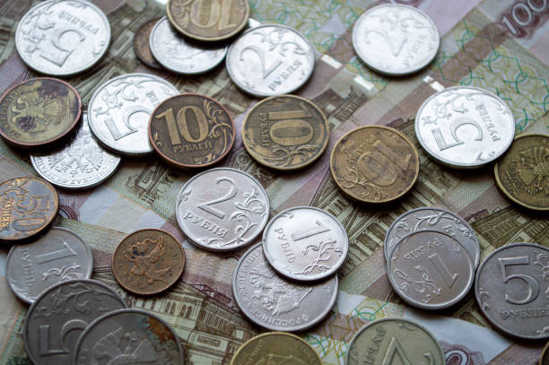 istock Russian currency, coins and banknotes lie on a wooden surface 2159763093