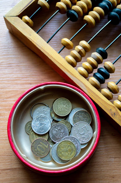 istock Russian currency, coins lie next to hand abacus on a wooden surface 2159764604