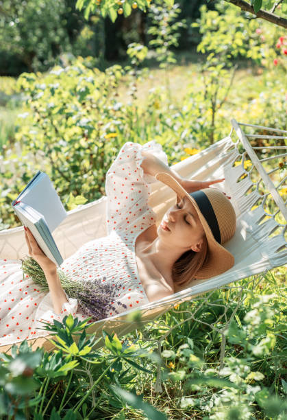 istock Young woman relaxing in a hammock outdoors in back yard 2159767355