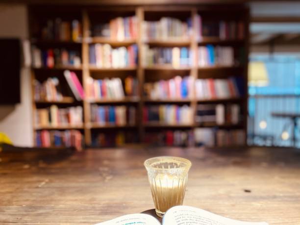 A drink and a book in front of the bookshelf