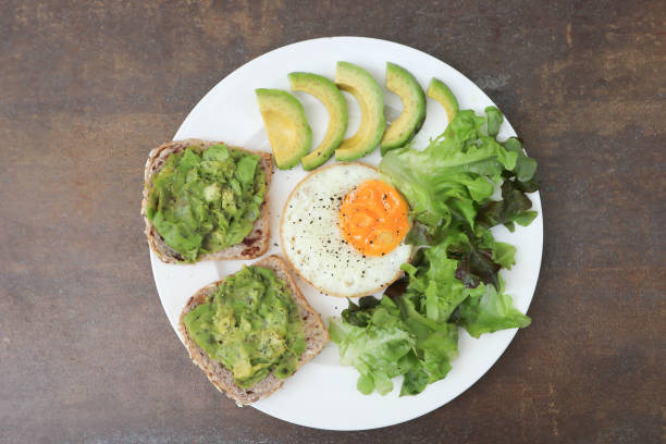 istock bread with mashed avocado topping ,sunny side up egg with lettuce and avocado for serve 2159767964