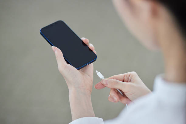 istock A Japanese woman's hand plugging a charger cord into a smartphone 2159768012