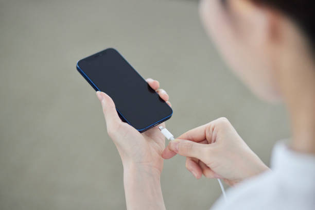 istock A Japanese woman's hand plugging a charger cord into a smartphone 2159768017