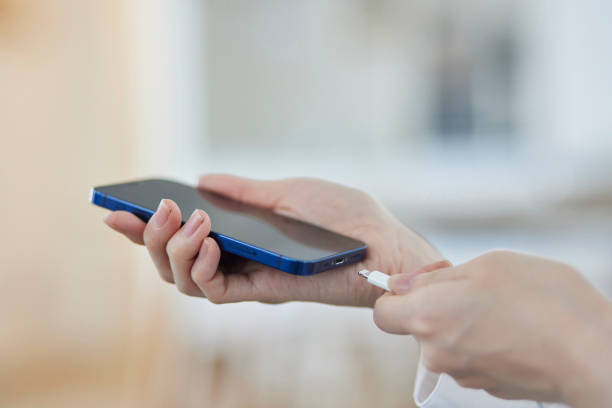 istock A Japanese woman's hand plugging a charger cord into a smartphone 2159768042