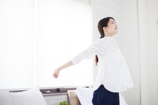 寝室でストレッチをする日本人女性 - リフレッシュ ストックフォトと画像
