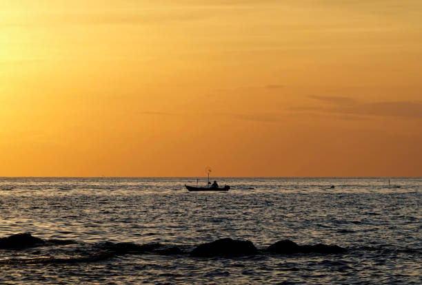 Fishing boat silhouette against sunset