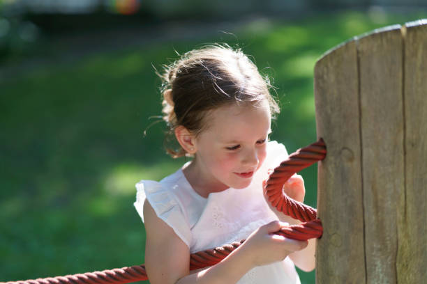 istock Preschooler with a missing tooth playing under the bright summer sun at the playground. 2159772976