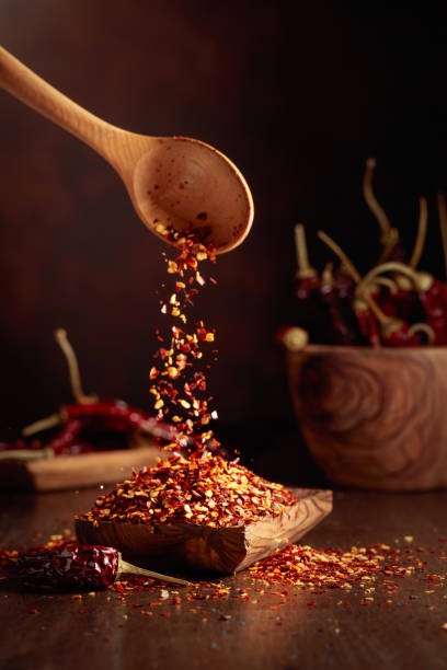 istock Chilli flakes are poured into a wooden dish. 2159775010