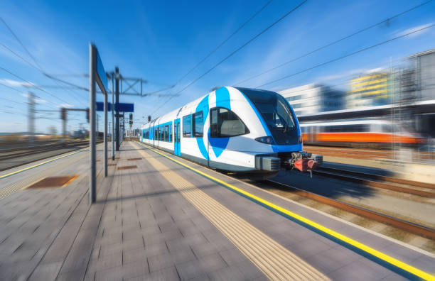 istock High-speed blue passenger train moving at railway station platform at sunset. Train station. Modern railway transportation concept with blurred motion effect. Railroad. Commercial transport 2159784116