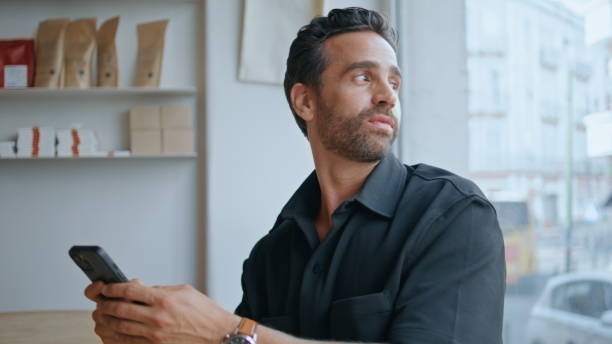 istock Bearded freelancer looking mobile phone in cafe closeup. Man reading phone sms 2159787154