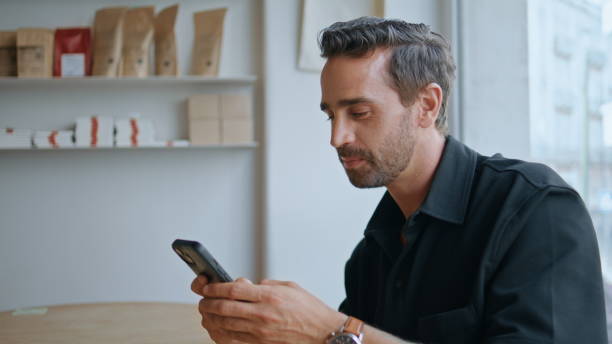 istock Smiling man reading sms on smartphone sitting cozy coffee house alone close up. 2159787324